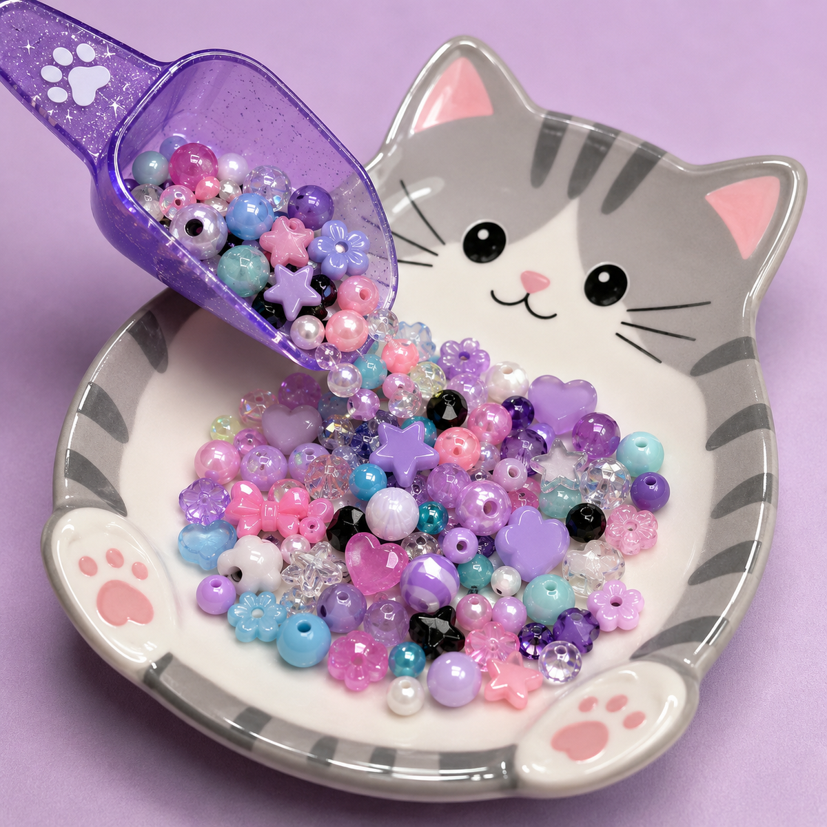 Purple glitter scoop pouring pastel beads onto a cat-shaped plate